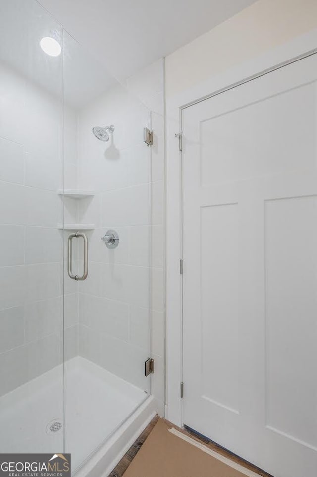 bathroom featuring a shower with door