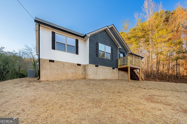 exterior space with central AC unit and a wooden deck