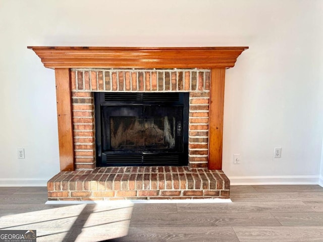 details with wood-type flooring and a brick fireplace