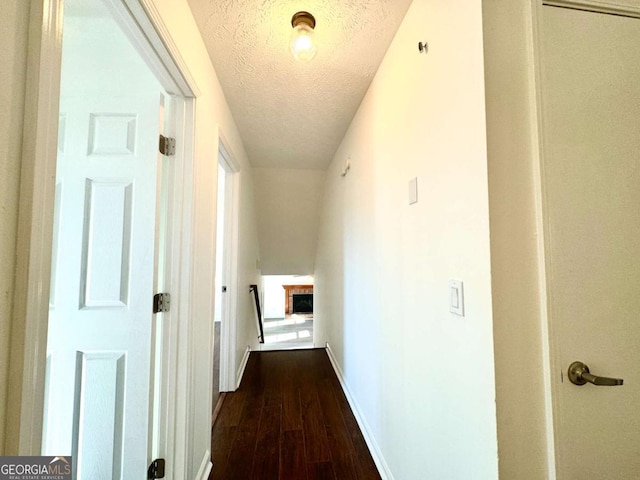 hallway with wood-type flooring and a textured ceiling