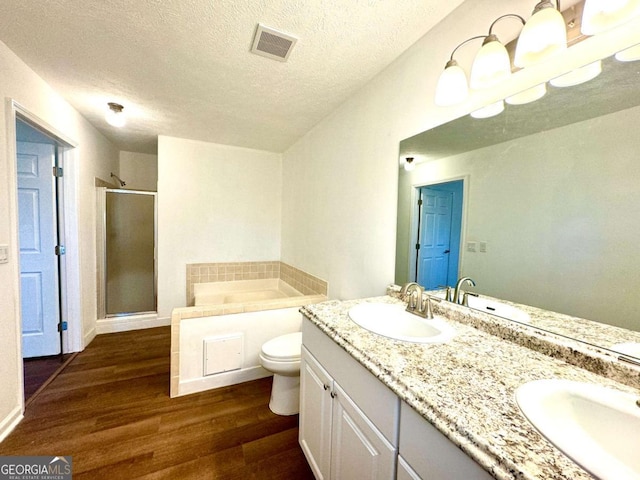 full bathroom with vanity, hardwood / wood-style flooring, toilet, shower with separate bathtub, and a textured ceiling