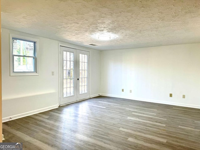 spare room featuring french doors, a textured ceiling, and dark hardwood / wood-style floors