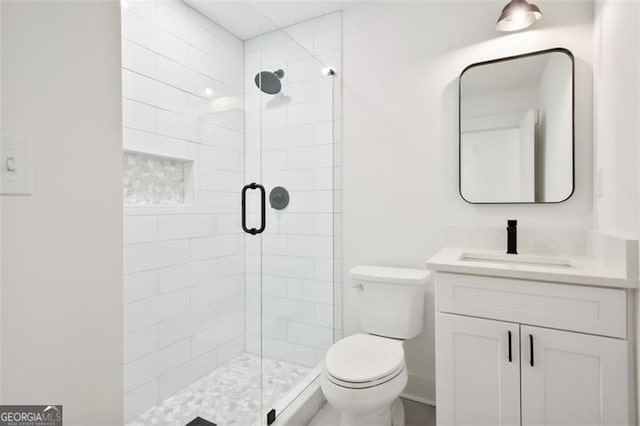 bathroom with vanity, toilet, and a shower with door