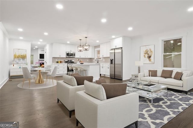 living room with dark hardwood / wood-style floors and a notable chandelier