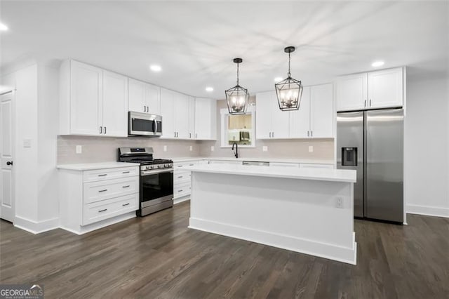 kitchen with a center island, white cabinetry, hanging light fixtures, and appliances with stainless steel finishes