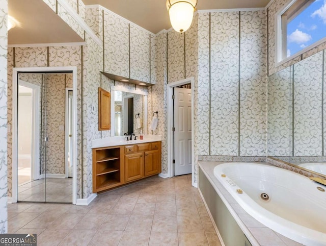 bathroom featuring vanity, tile patterned floors, crown molding, and a tub