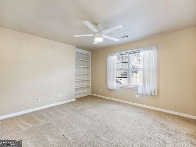 carpeted spare room with ceiling fan