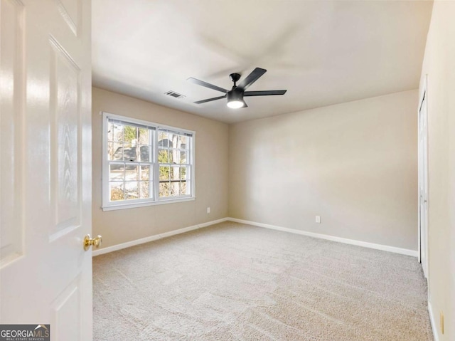 carpeted spare room with ceiling fan