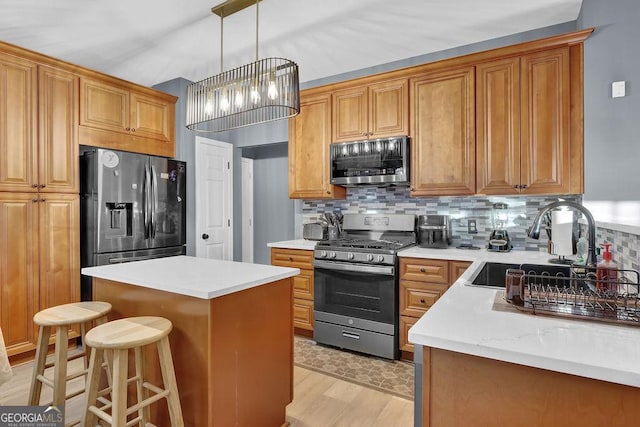 kitchen with a center island, stainless steel appliances, an inviting chandelier, light hardwood / wood-style flooring, and decorative backsplash