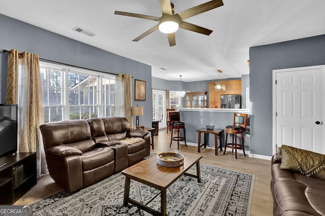 living room featuring ceiling fan and light hardwood / wood-style flooring