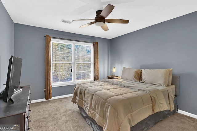 carpeted bedroom with multiple windows and ceiling fan