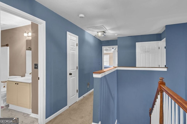 hallway featuring sink and light colored carpet