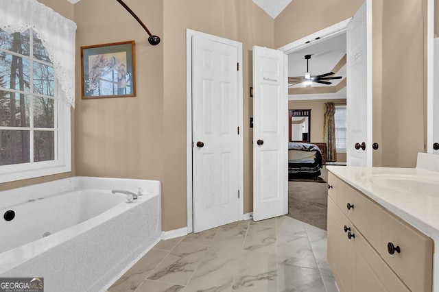 bathroom featuring ceiling fan, vanity, and a bath