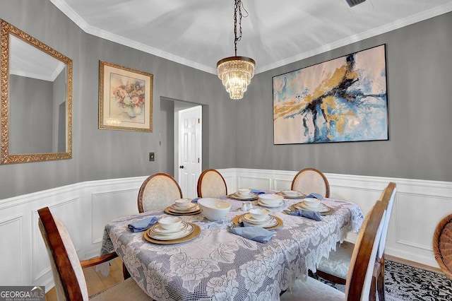 dining room with hardwood / wood-style floors, crown molding, and a notable chandelier