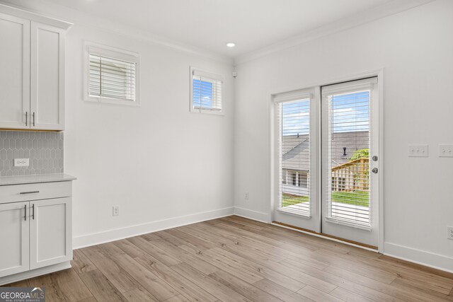 unfurnished dining area with crown molding and light hardwood / wood-style flooring