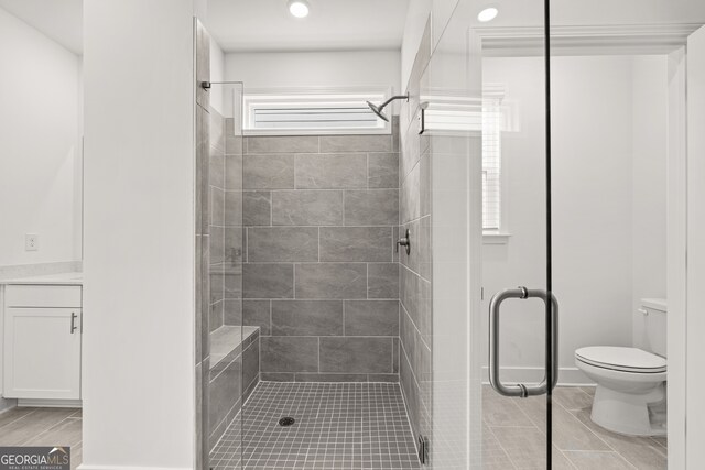 bathroom featuring vanity, toilet, and an enclosed shower