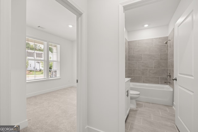 full bathroom with tiled shower / bath combo, toilet, and vanity