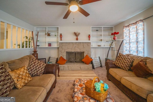 living room featuring ceiling fan and a stone fireplace