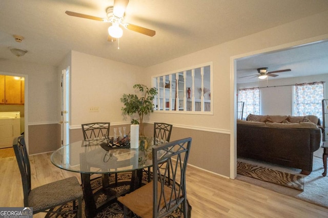 dining space with independent washer and dryer, ceiling fan, and hardwood / wood-style floors