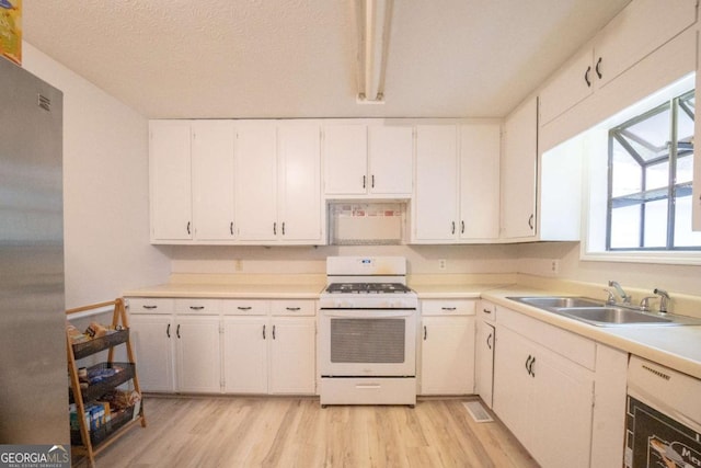 kitchen featuring white cabinetry, light wood-type flooring, white range with gas stovetop, and sink