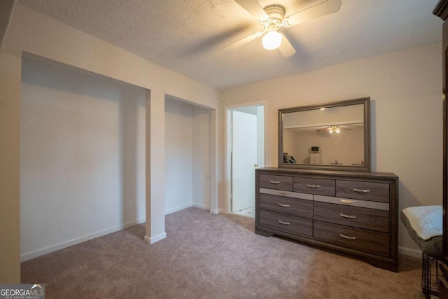 bedroom featuring ceiling fan, light colored carpet, and a textured ceiling