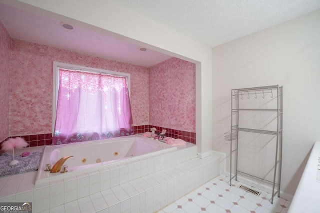 bathroom with a textured ceiling and tiled tub