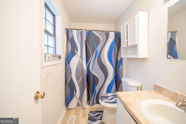 bathroom with hardwood / wood-style floors, vanity, and toilet