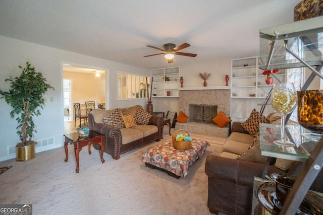 living room with a fireplace, carpet floors, and ceiling fan