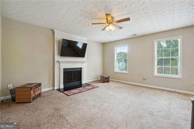 unfurnished living room featuring ceiling fan, carpet, and a textured ceiling