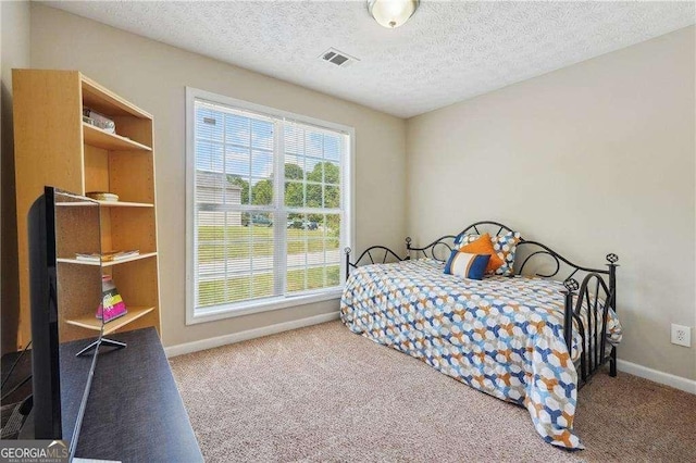 bedroom featuring carpet and a textured ceiling