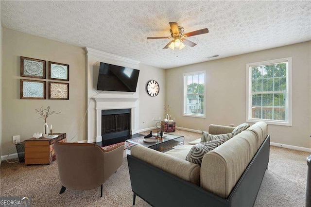 living room with light carpet, ceiling fan, and a textured ceiling