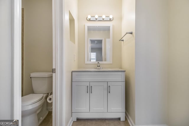 bathroom featuring vanity, tile patterned floors, and toilet