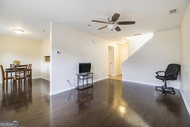 living room featuring ceiling fan and dark hardwood / wood-style flooring