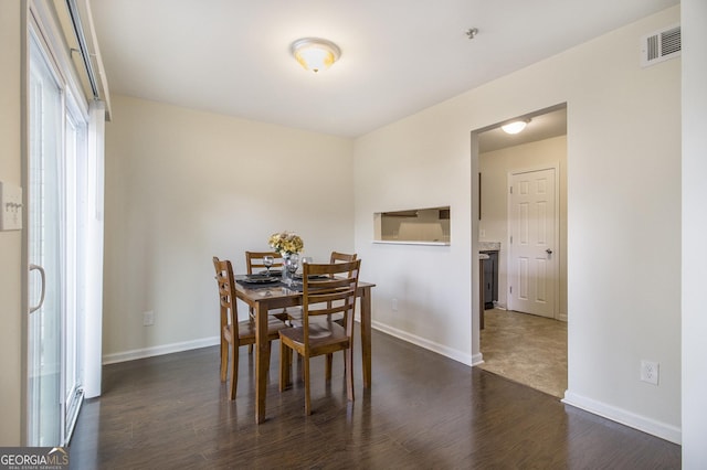 dining space with dark wood-type flooring