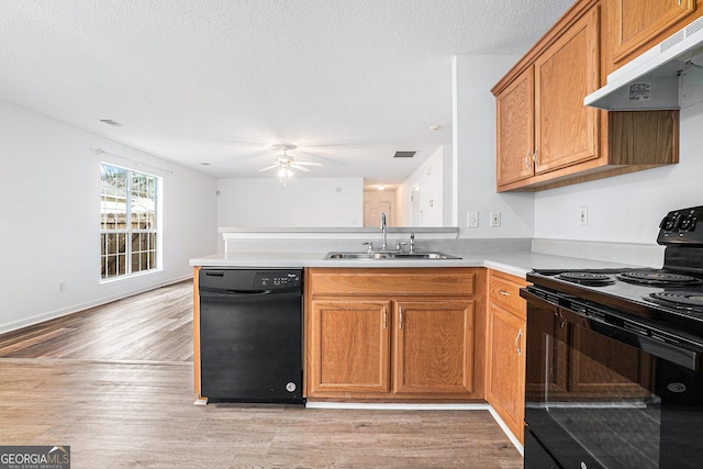 kitchen featuring ceiling fan, sink, range hood, kitchen peninsula, and black appliances