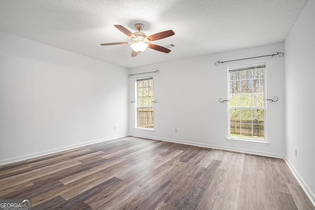 spare room featuring ceiling fan, wood-type flooring, and a textured ceiling