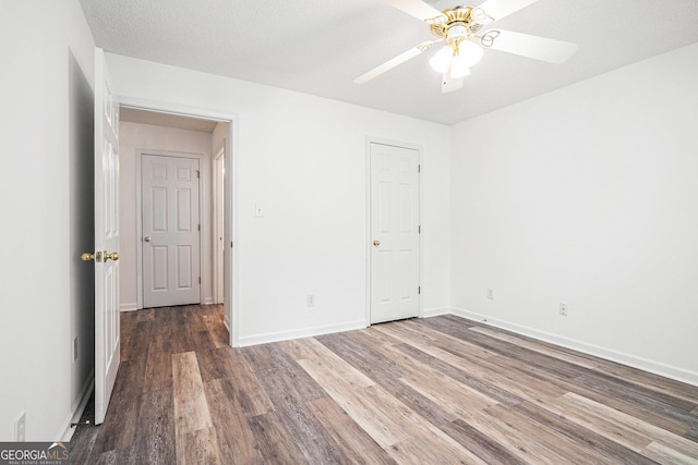 unfurnished bedroom featuring a textured ceiling, dark hardwood / wood-style flooring, and ceiling fan