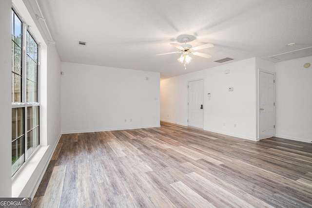 spare room with ceiling fan, wood-type flooring, and a textured ceiling