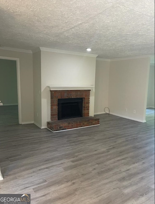 unfurnished living room featuring ornamental molding, wood-type flooring, and a brick fireplace