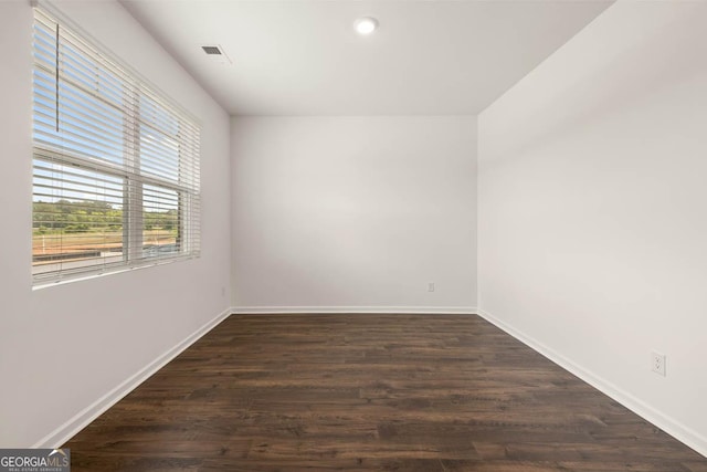 empty room with dark hardwood / wood-style flooring