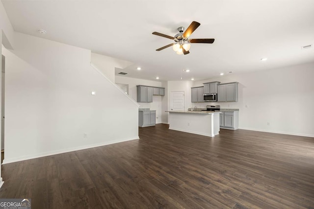 unfurnished living room with ceiling fan, dark hardwood / wood-style flooring, and sink