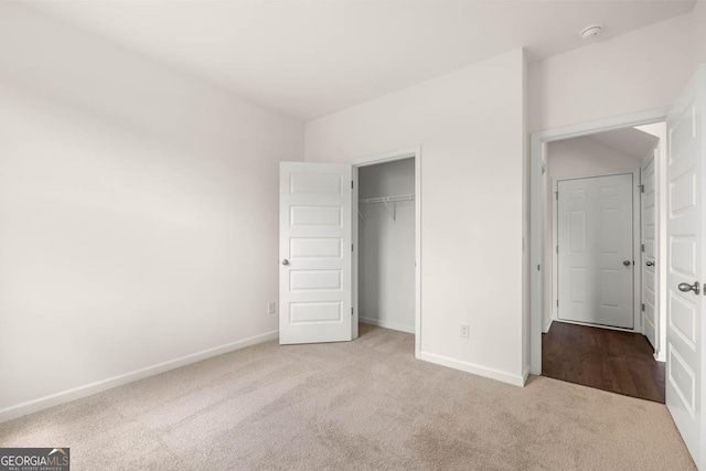 unfurnished bedroom with light carpet and a closet