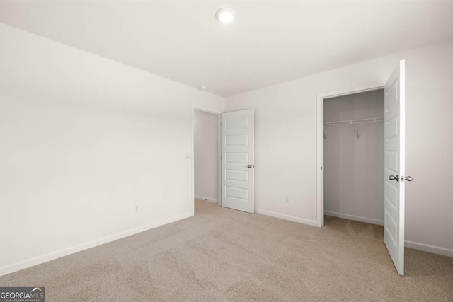 unfurnished bedroom with light carpet and a closet