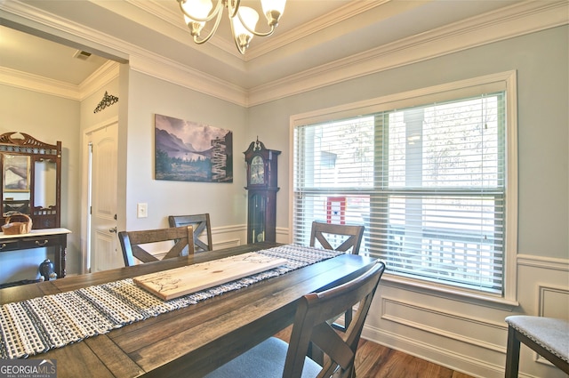 dining area with a healthy amount of sunlight, dark hardwood / wood-style flooring, crown molding, and an inviting chandelier