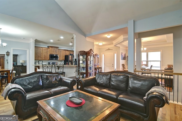 living room featuring a chandelier, ornamental molding, light hardwood / wood-style floors, and lofted ceiling