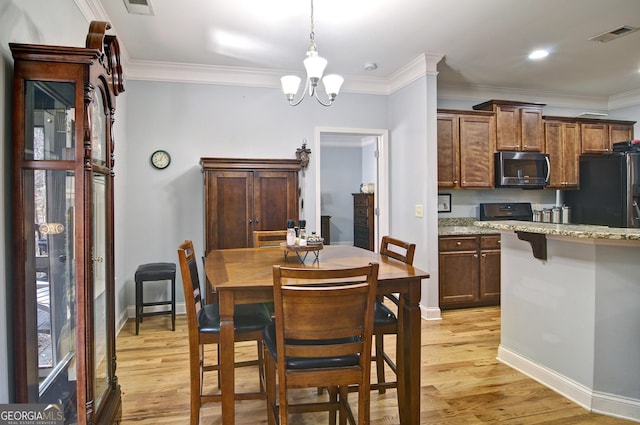 dining room featuring light wood-type flooring, an inviting chandelier, and ornamental molding