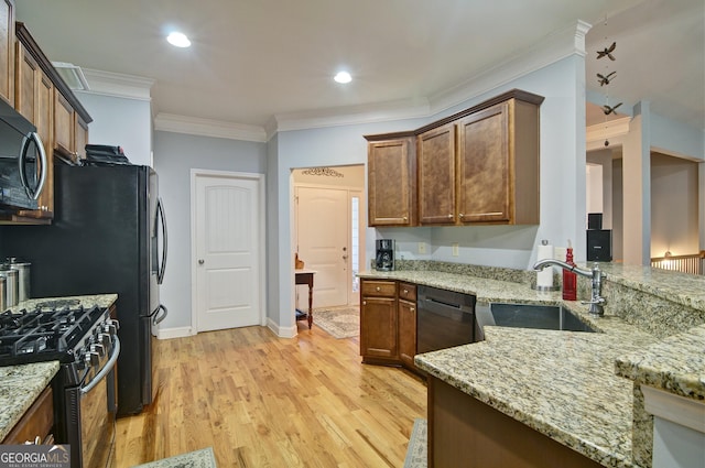 kitchen featuring light stone counters, high end stainless steel range oven, crown molding, sink, and light hardwood / wood-style floors