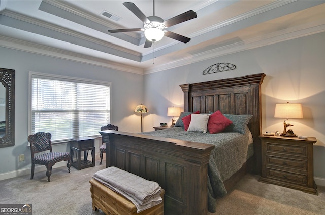 carpeted bedroom with a raised ceiling, ceiling fan, and crown molding