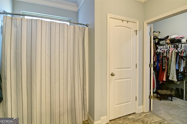 bathroom featuring crown molding and walk in shower