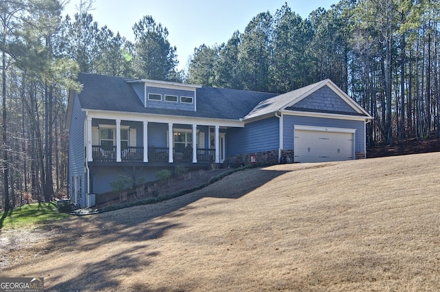 craftsman inspired home featuring a front yard, a porch, and a garage